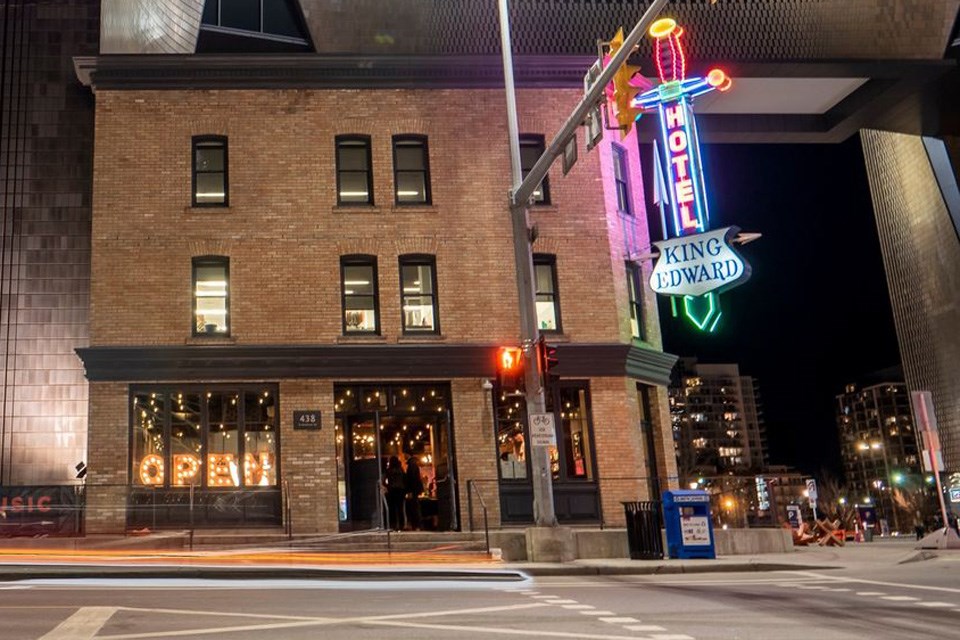 The outside of the King Edward Hotel in downtown Calgary, with lights and a lively crowd inside. / The King Eddy | Facebook