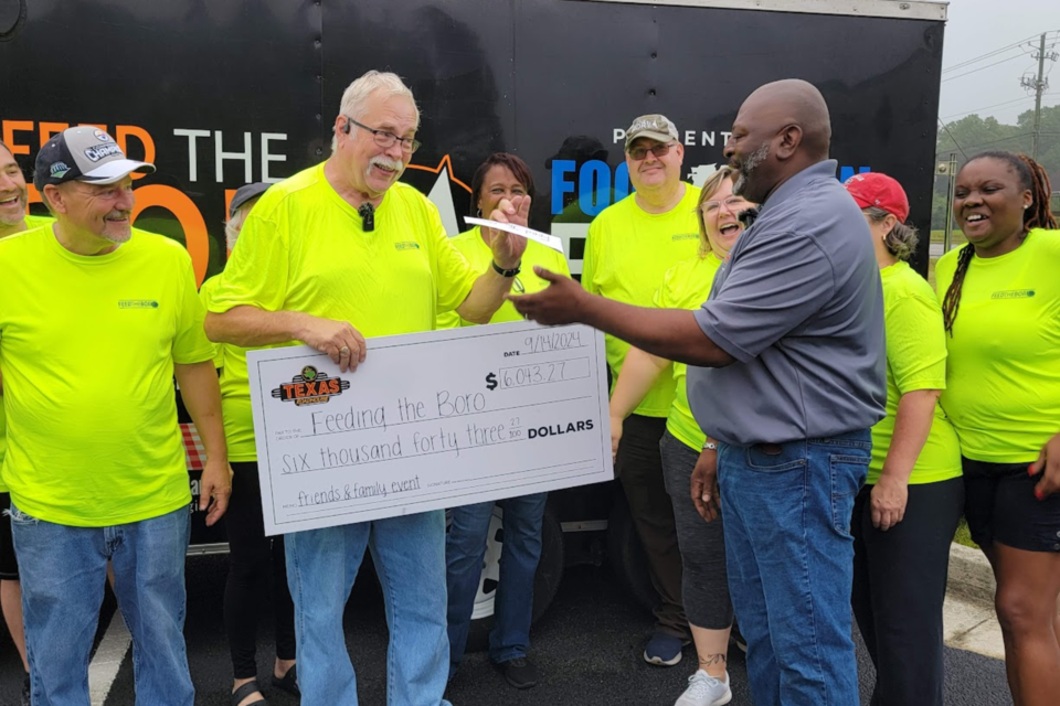 Don Poe receives check from Maurice Jackson