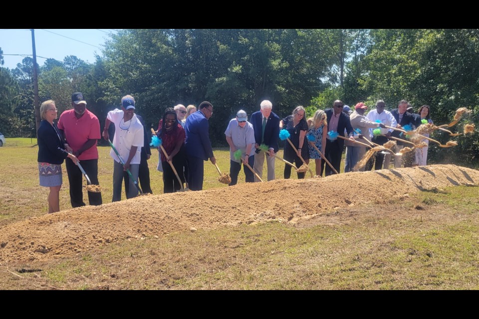 Representatives for the food bank, city and county officials, and state and federal representatives participate in the ceremony