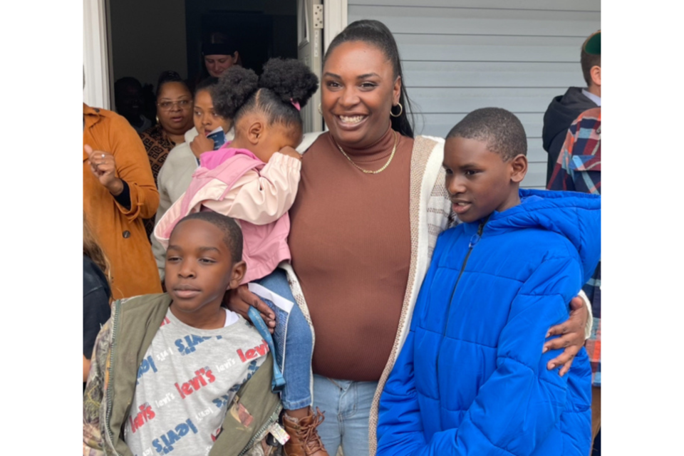 Maria Lipsey and her 3 children pose for a family photo in front of their new home built by Habitat for Humanity of Bulloch County. 