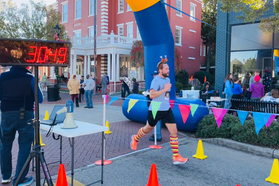 Runner Mark Anderson finishes the race decked out in turkey-themed attire