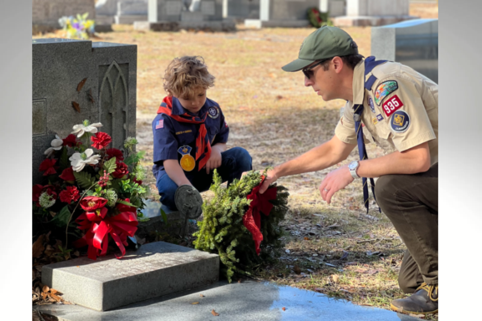 Cubmaster of Pack 935 Dustin Fackler helps his son Elliot place a wreath | Photo Courtesy Pack 935