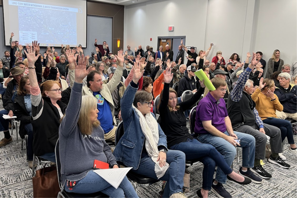 Attendees raising their hands to indicate they are against drilling wells in Bulloch County