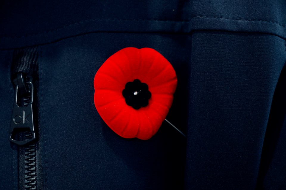 Man wears Remembrance Day poppy.