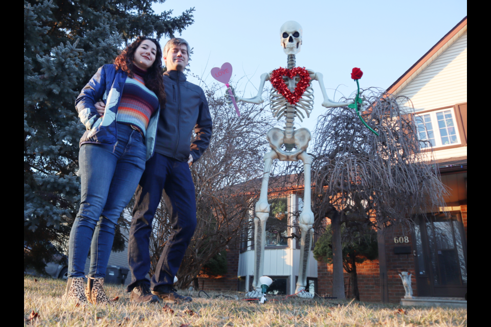 Christina Vasquez and Kevin Dickson in front of their 12 foot tall skeleton at their home on Edinburgh Road South.