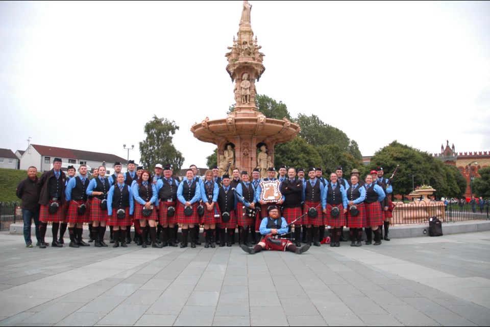 The Grade 3A Guelph Pipe Band in front of the Doulton Fountain near the competition arena for World Pipe Band Championships .                 