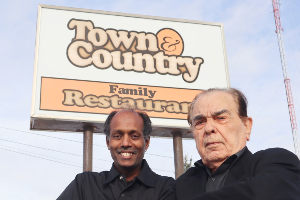 Town & Country restaurant owner Jeyakopalan Nagalingam and long time building owner of 683 Eramosa Rd., Tom Kostas, who started the restaurant in 1973 stand in front of the restaurant's old and iconic sign.