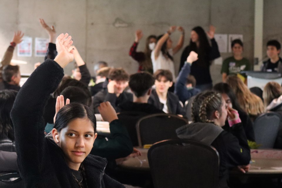 Students raising their hands who have hopes for the planet to improve. 