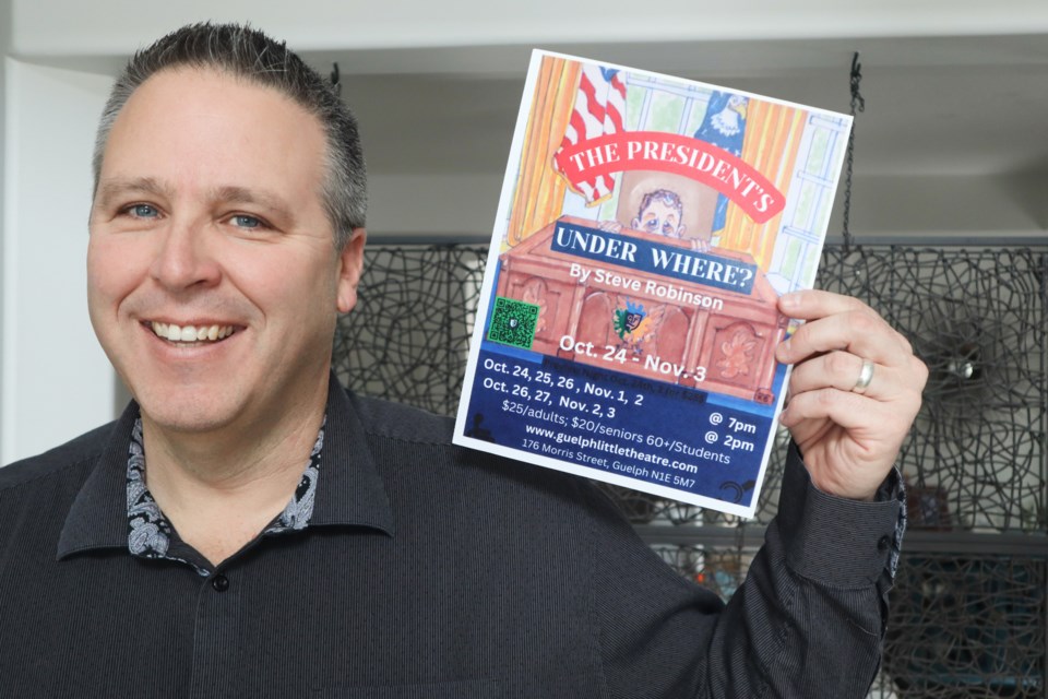 Newly retired Dean Curtis holding a poster of the Guelph Little Theatre play he was in.