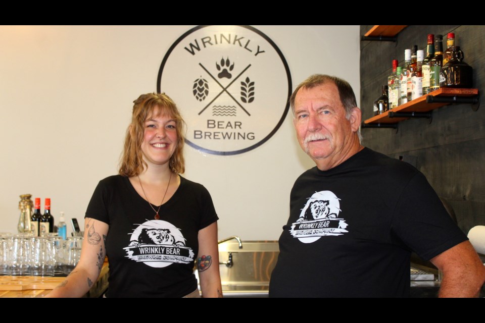 Wrinkly Bear Brewing co-owner Larry Matlashewski stands behind the taproom bar with bartender Jadelyn Appleby.