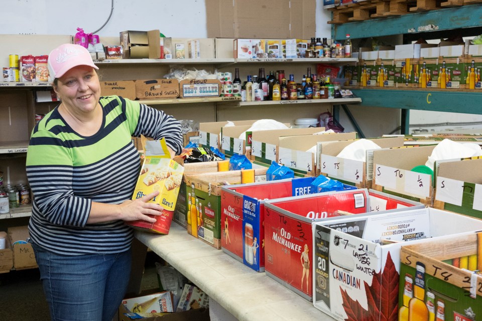 Ingrid, a volunteer at the Guelph Food Bank, fills boxes as part of the organization's hamper program. Kenneth Armstrong/GuelphToday