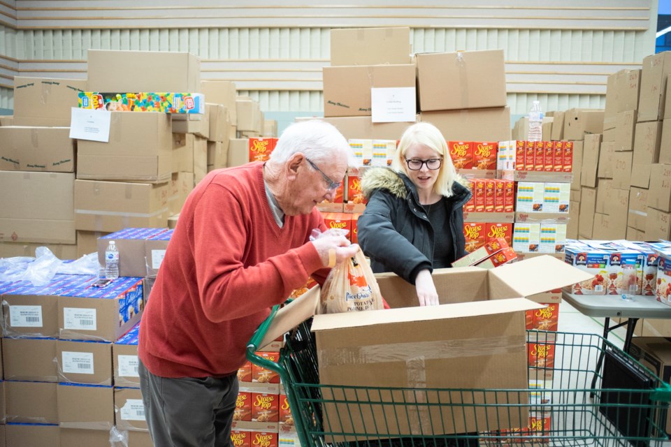 Volunteers fill a box with food items as part of the Salvation Army's Christmas Hamper program. This year, more than 1,100 of the hampers will be delivered to people in need in Guelph. Kenneth Armstrong/GuelphToday