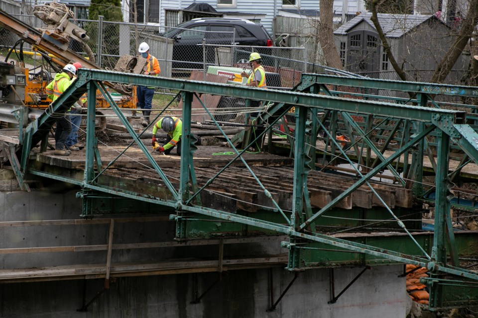 A worker saws into planks at the eastern end of the Norwich Street bridge. The construction is expected to continue until mid-July. Kenneth Armstrong/GuelphToday