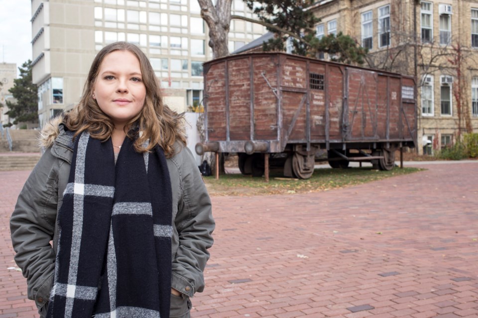 Aleeza Karp, co-chair of Hillel’s Holocaust Education Week committee, stands near the Holocaust Cattle Car exhibit currently on display at the University of Guelph Campus. The railcar is a reproduction of ones used to transport people to concentration camps during World War Two. Kenneth Armstorng/GuelphToday