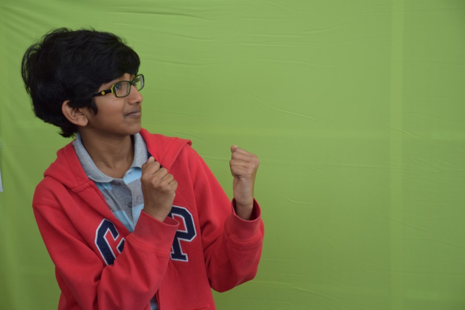 Rohan Patankar, 11, puts his dukes up in front of a green screen. A few steps on a computer screen showed him going up against Darth Vader.