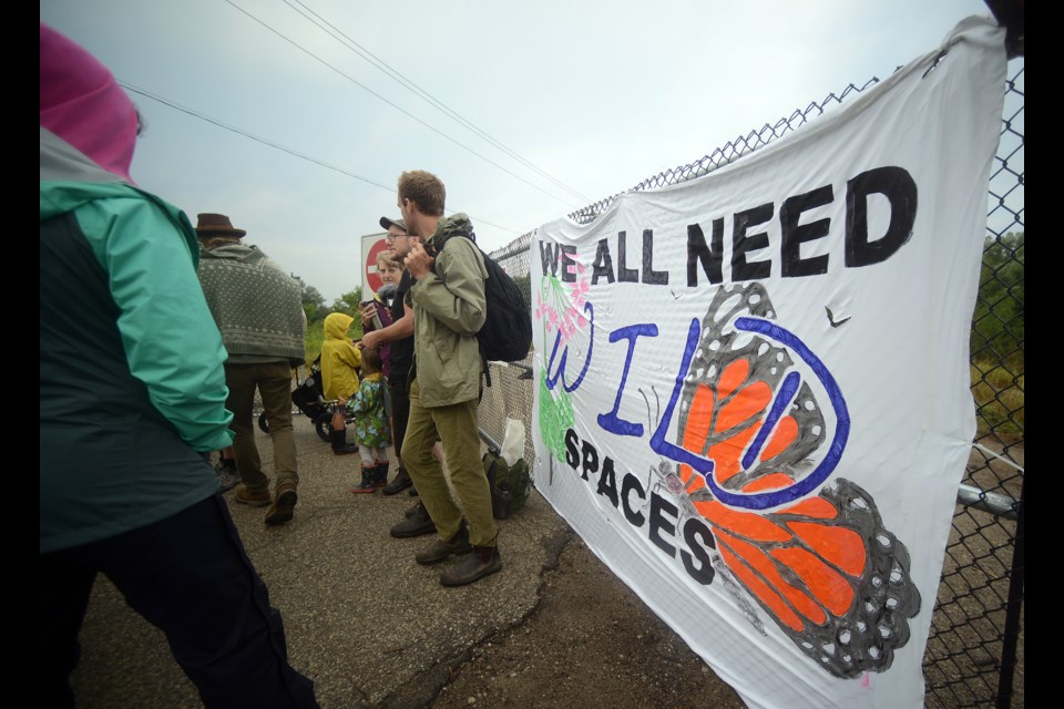 Roughly 30 people gathered at the edge of the Lafarge property on Silvercreek Parkway South Friday, Aug. 4, 2017, hoping to delay any removal of trees on the property. Tony Saxon/GuelphToday