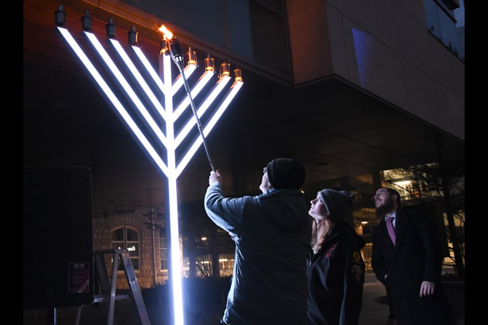 Howard Partnoy was the first to light a nine-foot tall menorah in front of city hall on Sunday, during a celebration hosted by Chabad of Guelph.