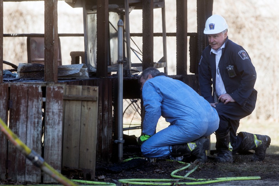 Investigators with Guelph Fire Department look under the deck at the scene of a house fire March 26, 2018 at 20 Hooper Street. Kenneth Armstrong/GuelphToday