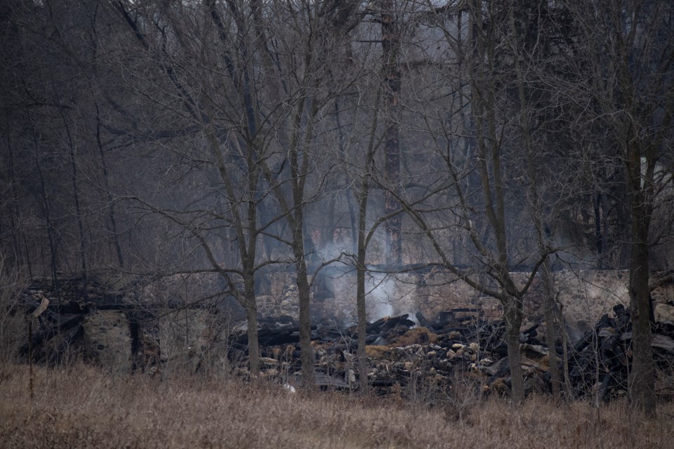 The remains of a barn continue to smoulder Monday morning after a Sunday evening fire on Highway 6 in the city's north end. Kenneth Armstrong/GuelphTOday