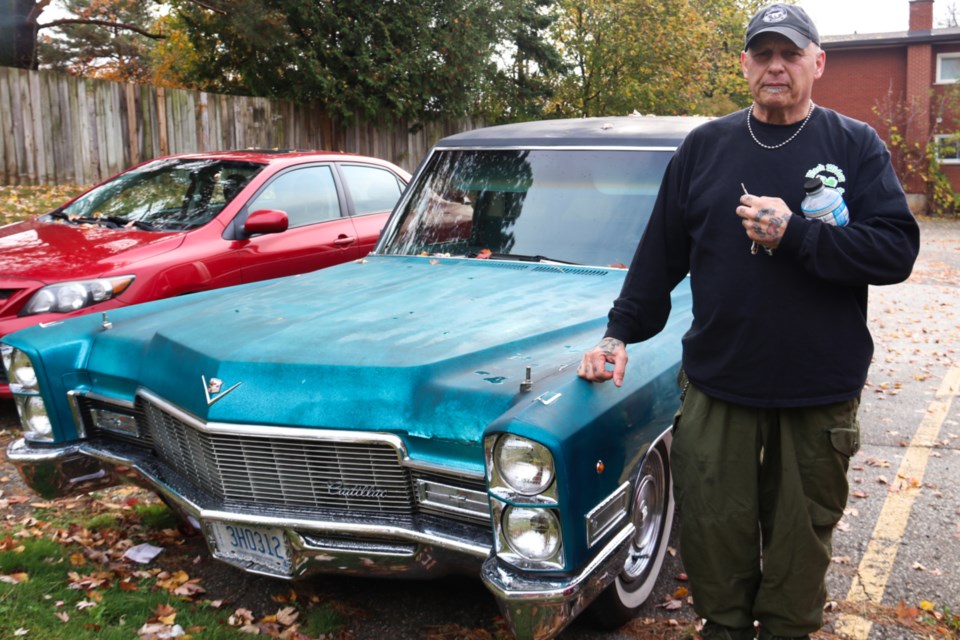 Paul Sauve stands next to his 1968 Cadillac Superior Hearse. 