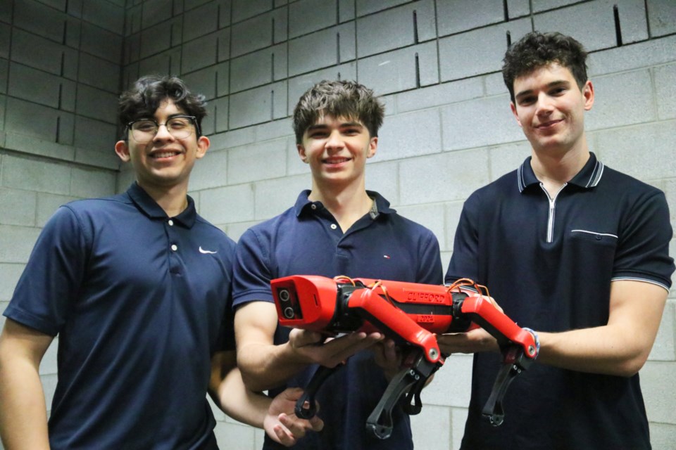 U of G students Matthew Salazar, Chase Keeler and Cameron Bauman with their robot dog, Clifford.