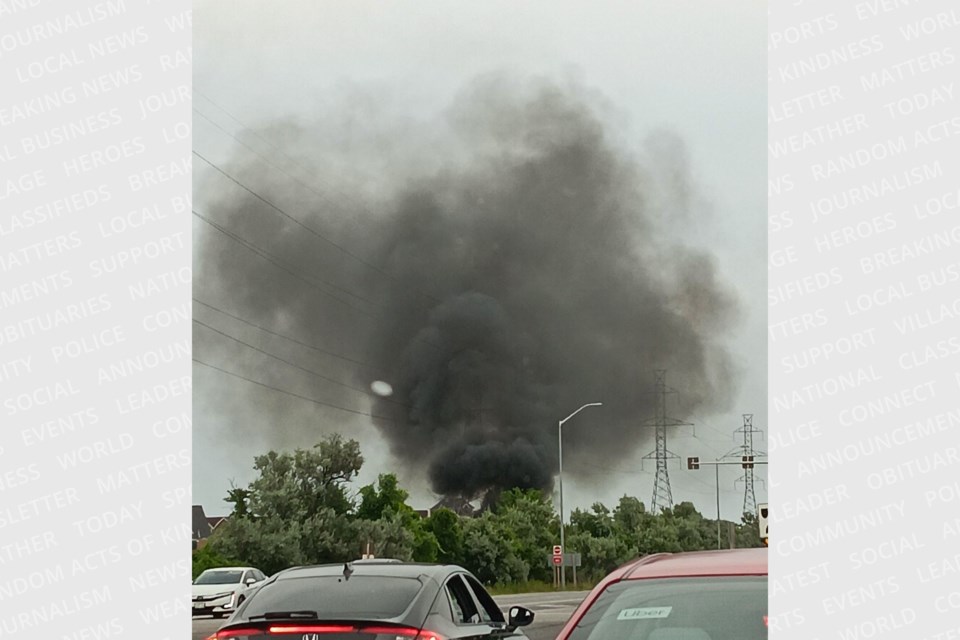 Thick black smoke rises above an encampment fire by the Hanlon Expressway and Speedvale Avenue on Monday evening.