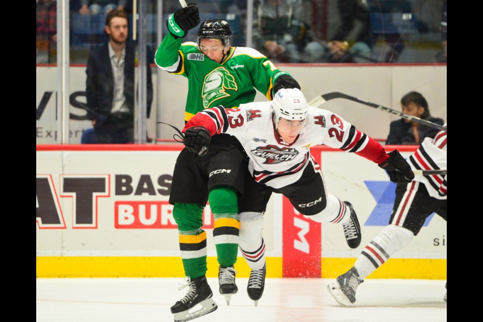 The Guelph Storm's Charlie Paquette delivers an open ice hit on the London Knights'Will Nicholl Sunday at the Sleeman Centre.