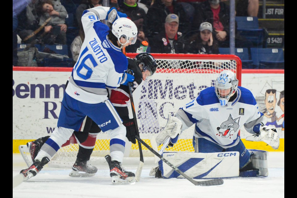 Guelph's Leo Serlin is checked by Sudbury's Jack Ziliotto as he tries toget a rebound off goaltender Finn Marshall.