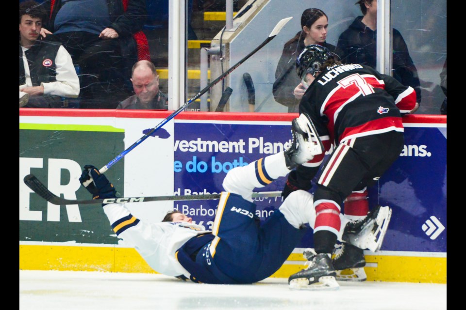 The Guelph Storm's Jett Luchanko levels an Erie Otters defenceman in the first period Thursday at the Sleeman Centre.