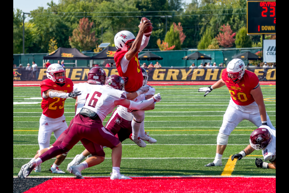 Quarterback Marshall McCray (1) of the Guelph Gryphons leaps into the end zone for a touchdown despite the efforts of defensive back Braxton Peters (6) of the McMaster Marauders during OUA football play Saturday at Alumni Stadium. The touchdown, McCray's fourth in as many games this season, helped the Gryphons down McMaster 29-24.