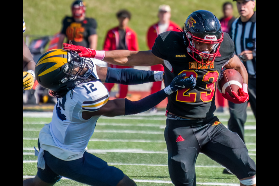 Running back Donavin Milloy (23) of the Guelph Gryphons delivers a straight arm to Isaac White (12) of the Windsor Lancers in OUA football play Saturday at Alumni Stadium. The Gryphons handed the Lancers a 45-40 loss, the first defeat of the season for Windsor.