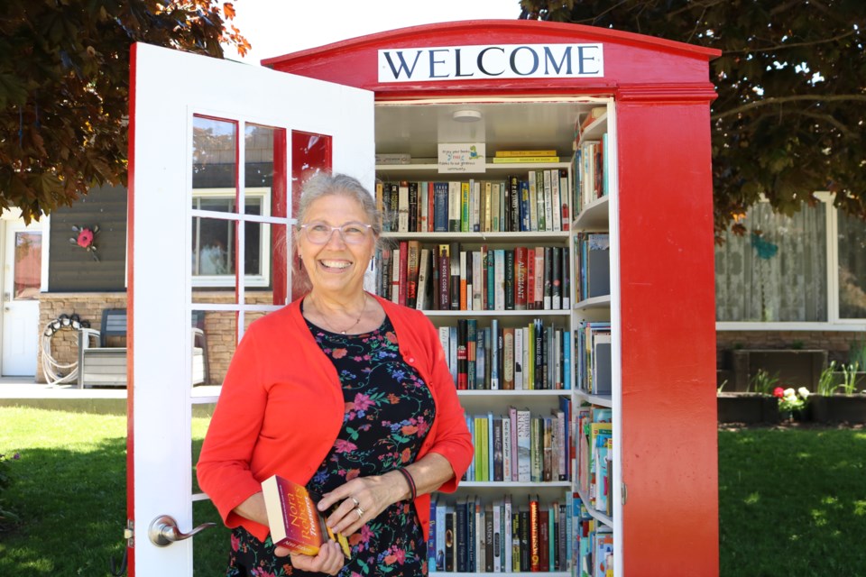 Drayton resident Glynis Belec stands in front of her Little Red Library.