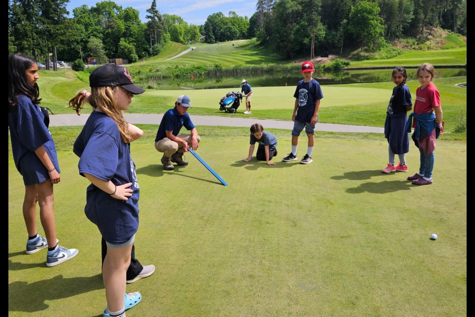 David MacKenzie demonstrates to students how the turf crew at The Club at North Halton tests the speed of the greens. 