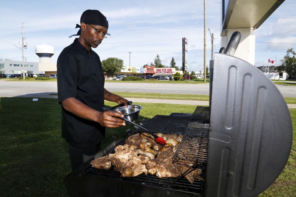 Kurtis Monlouis grills up some chicken for his food truck, Louis Kitchen.