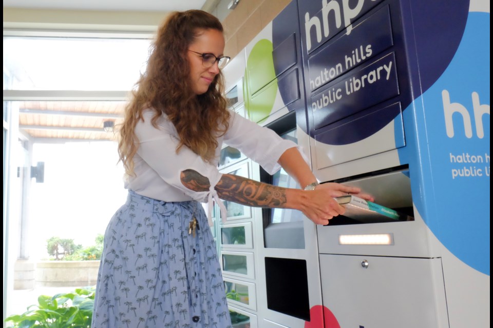 Systems Librarian Jen Corrin demonstrates how to return books using the lockers. 