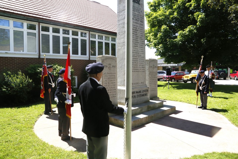 A member of the Acton Legion stands ready to lower the flag at half mast to commemorate the 80th anniversary of D-Day. 