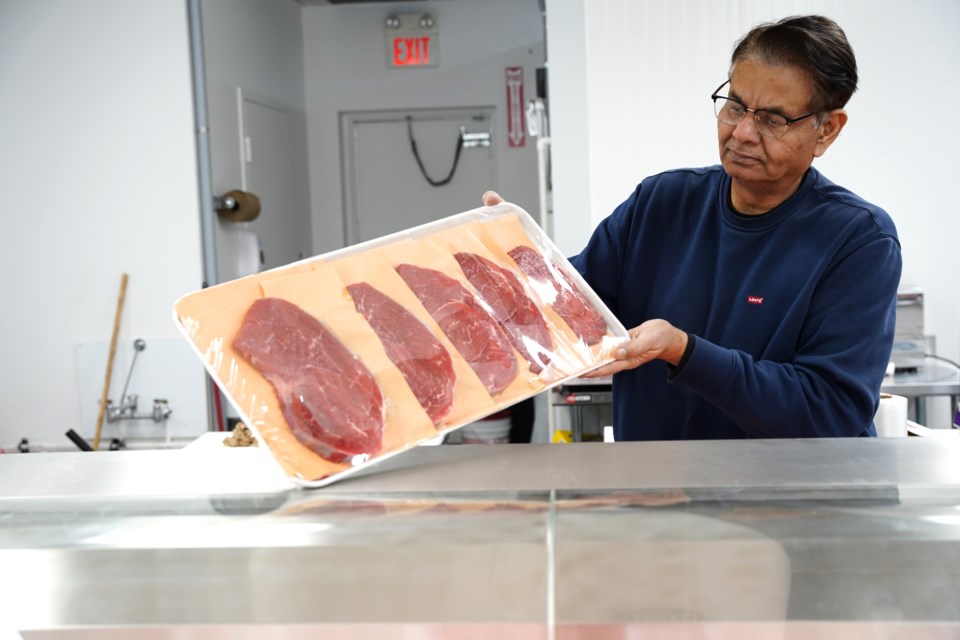 Khurram Danyal shows a tray full of AAA sirloin steaks. 