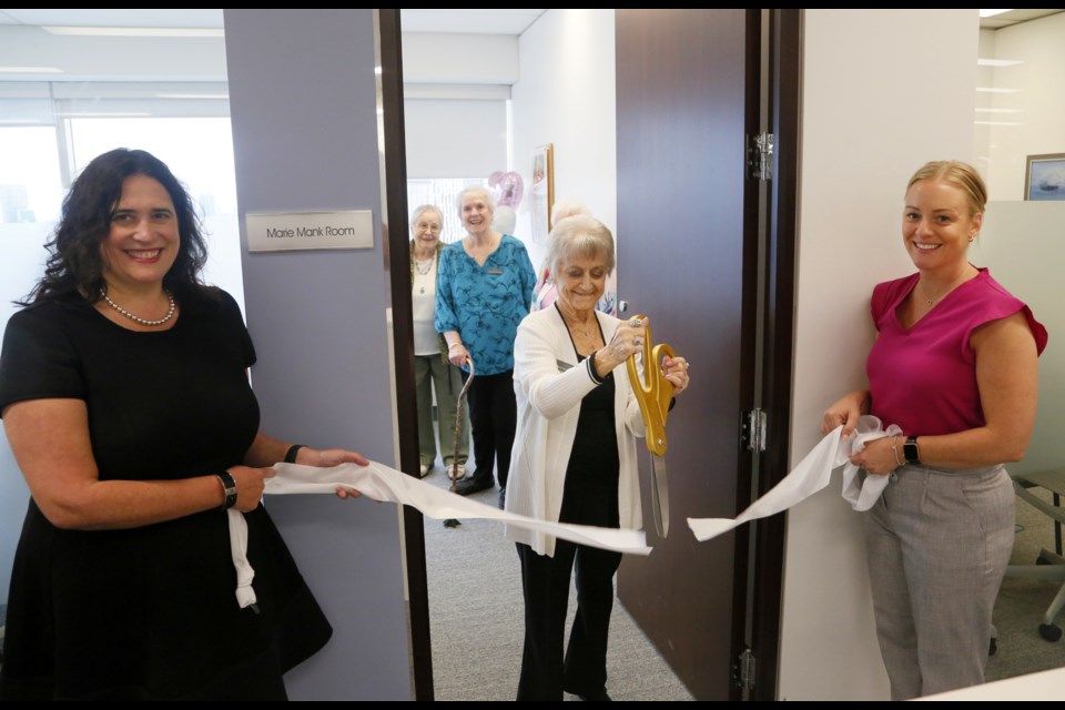 Marie Mank cuts the ribbon on the newly-renamed boardroom, with Amica CFO Christine Albinson (left) and Marketing Manager Allison Shaw holding the ribbon.