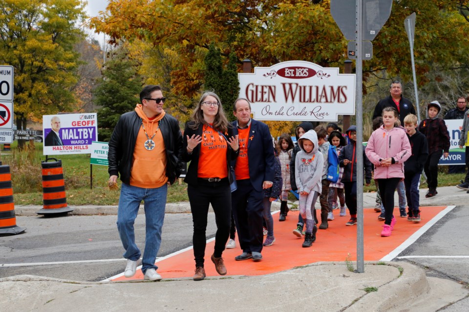 Dignitaries lead local school kids in a ceremonial crossing of the intersection. 