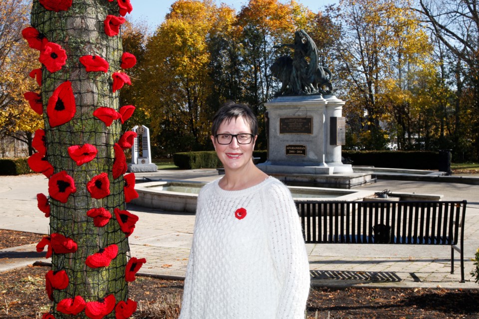 Christine Arbic poses with one of the many trees adorned with poppies.