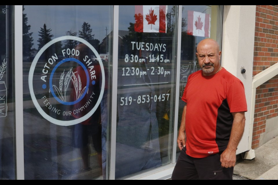 Ward 1 Councillor Mike Albano stands outside Acton Foodshare. The logo was designed by Vanessa Lewicki, a local artist who does displays on shop windows. 