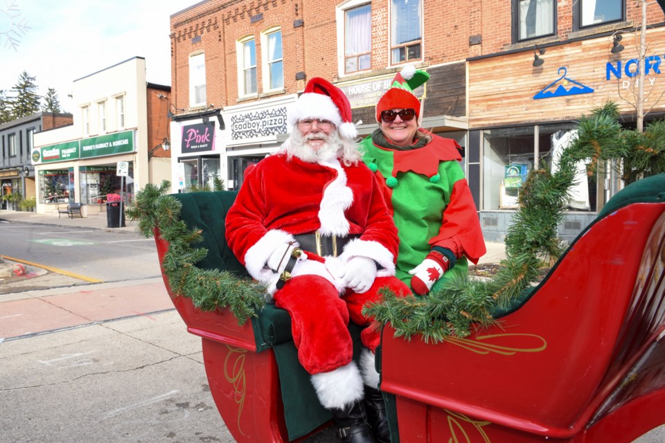 Santa, shown with one of his elves, at the Georgetown Holiday Market on Main Street.