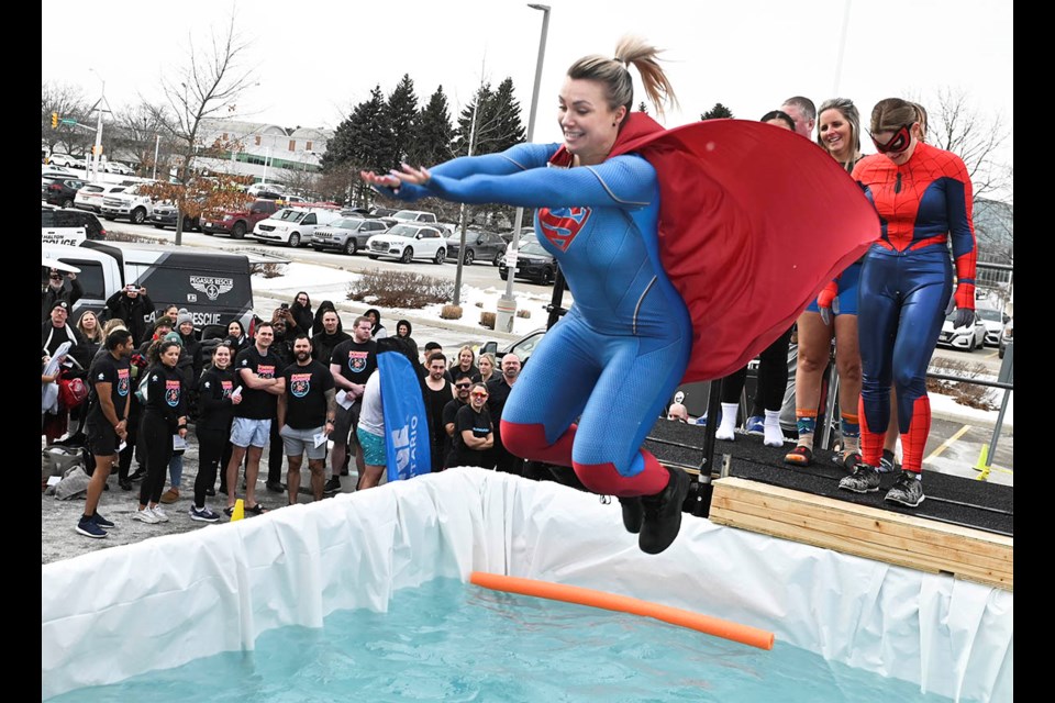 Halton police A/Sgt Ashley Lillian of the community mobilization unit, aka Supergirl, leaps into the frigid water during the inaugural Halton Police Polar Plunge in support of Special Olympics Ontario.