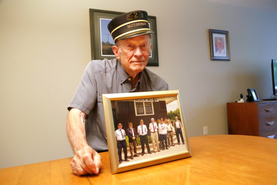 Bob Sandusky poses with a photo of him and his friends who founded the Halton Country Radial Railway Museum together. 