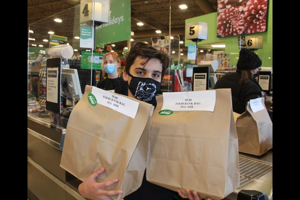 Sobeys' cashier Lita Hardacre, 20, helps Jack Ghanem, 12, load up on donation bags to bring to the Sobeys' toy drive trailer in the parking lot Dec. 12. 