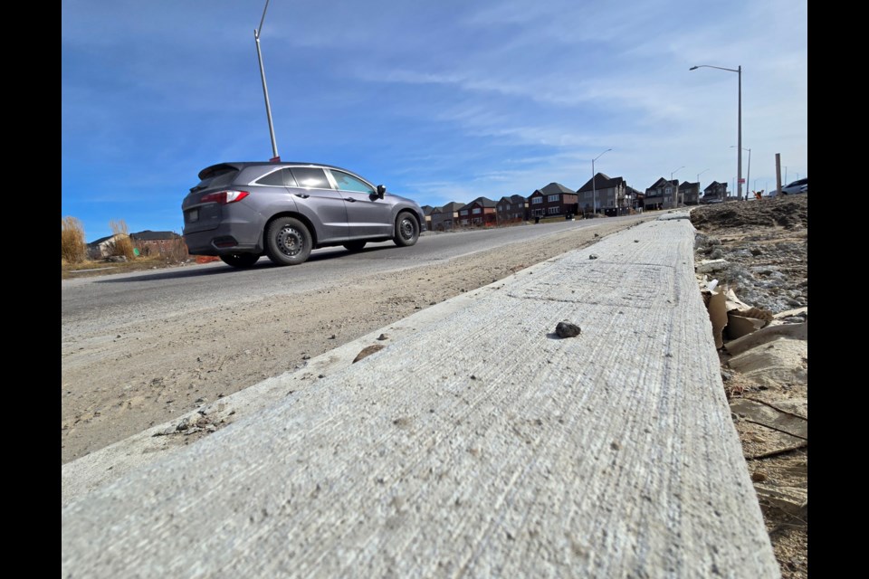 A vehicle travels along a recently opened stretch of Webster Boulevard, which now provides a connection for much of the road to the 6th Line.