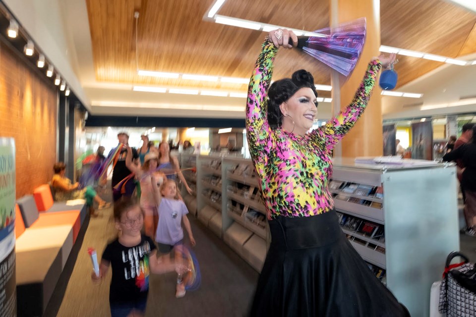 Drag Queen Justine D’as leads the group in dancing through the racks of books at the drag queen storytime event at the Innisfil ideaLAB and Library on Saturday afternoon. 