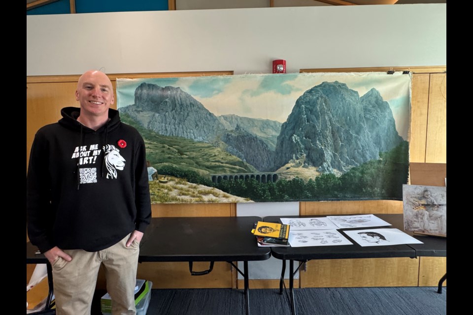 Liam Jones is pictured with his art titled Music of Paco de Lucia (acrylic), which is inspired by mountains he saw while on a trip to southern Spain.