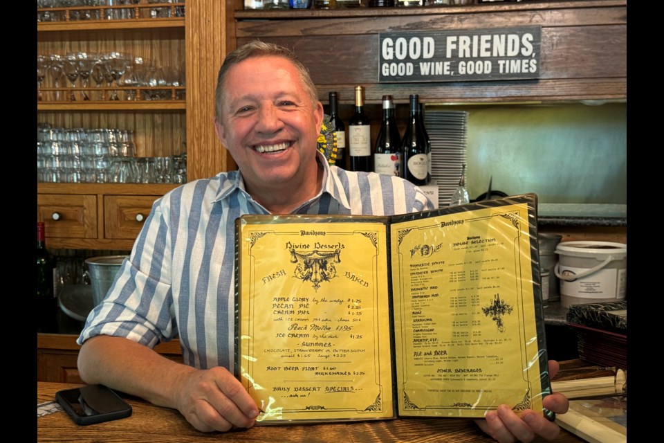 Dan Davidson bought Davidson's Country Dining in 1984. He is pictured holding a copy of the original menu offered to customers.