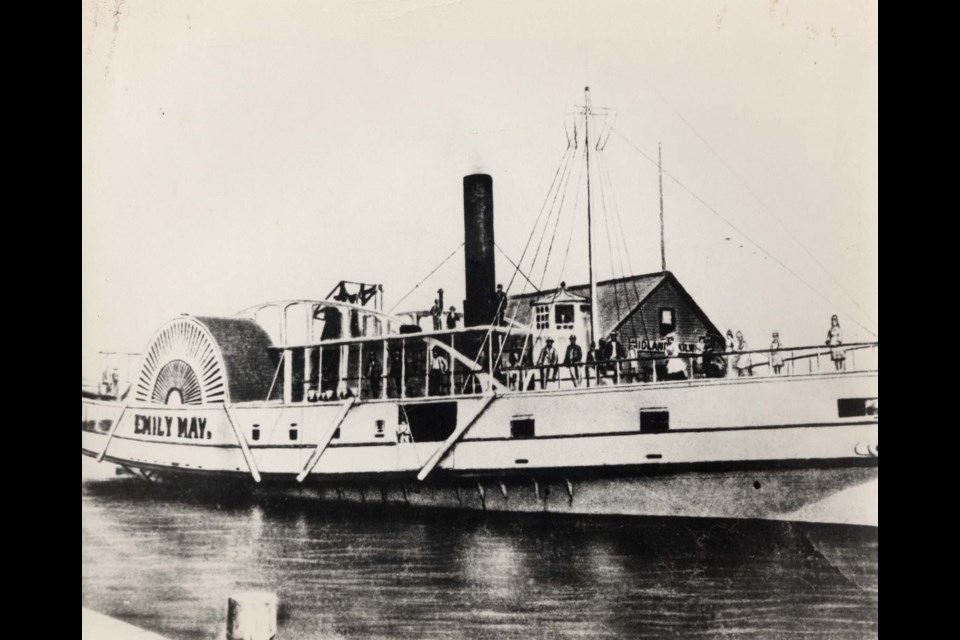 The Emily May was a Lake Simcoe excursion steamer whose hull lies off of Belle Ewart Park today. The photo shows a long white steamboat with one stack and the name EMILY MAY painted on the side, with a number of passengers standing on its deck. It was the largest and most serviceable paddle steamer on Lake Simcoe, known as a side-wheeler. The boat could carry 800 passengers and had a speed of 14 miles per hour. It was built in Belle Ewart by Isaac May in 1861 and was in service for 21 years doing both passenger and freight business, and made regular trips from Orillia, Barrie, and Holland Landing in addition to numerous excursion voyages.